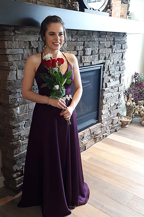 Girl in prom dress in front of fireplace